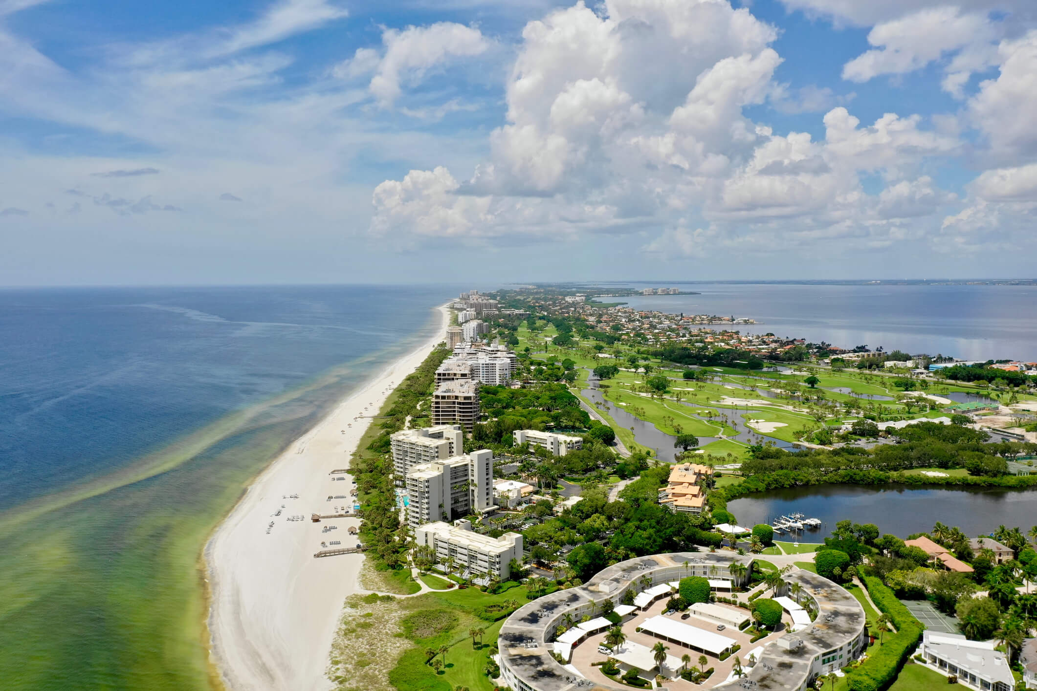 Compare barrier island living with inland master-planned communities across Sarasota and Manatee counties, including insurance, maintenance, and water access.