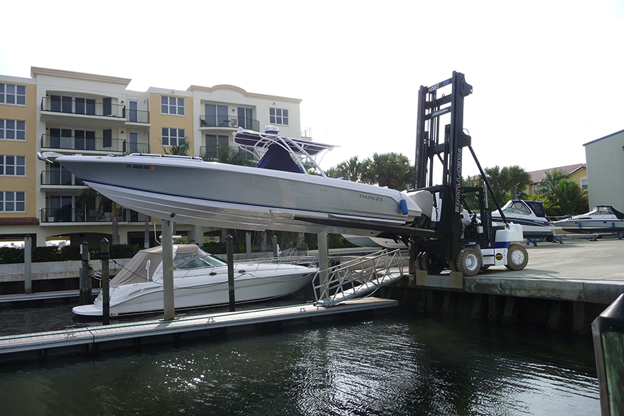 Loading a Donzi center console into the water at the local city marina.